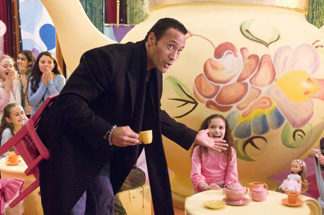 Sadly, the doll at the table has no way of smelling what the Rock is cooking.